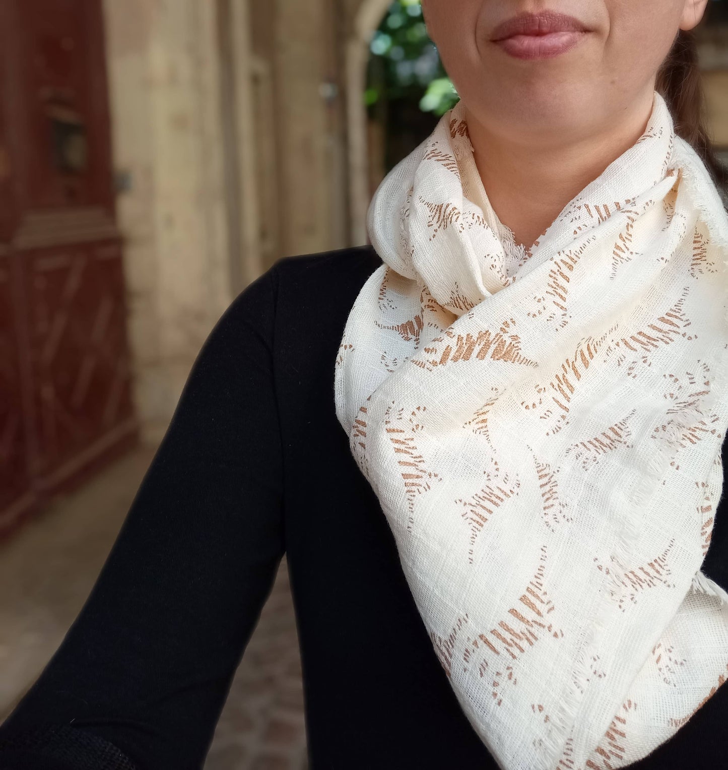 écharpe beige crème motif léger tigré portée autour du cou d'une femme
