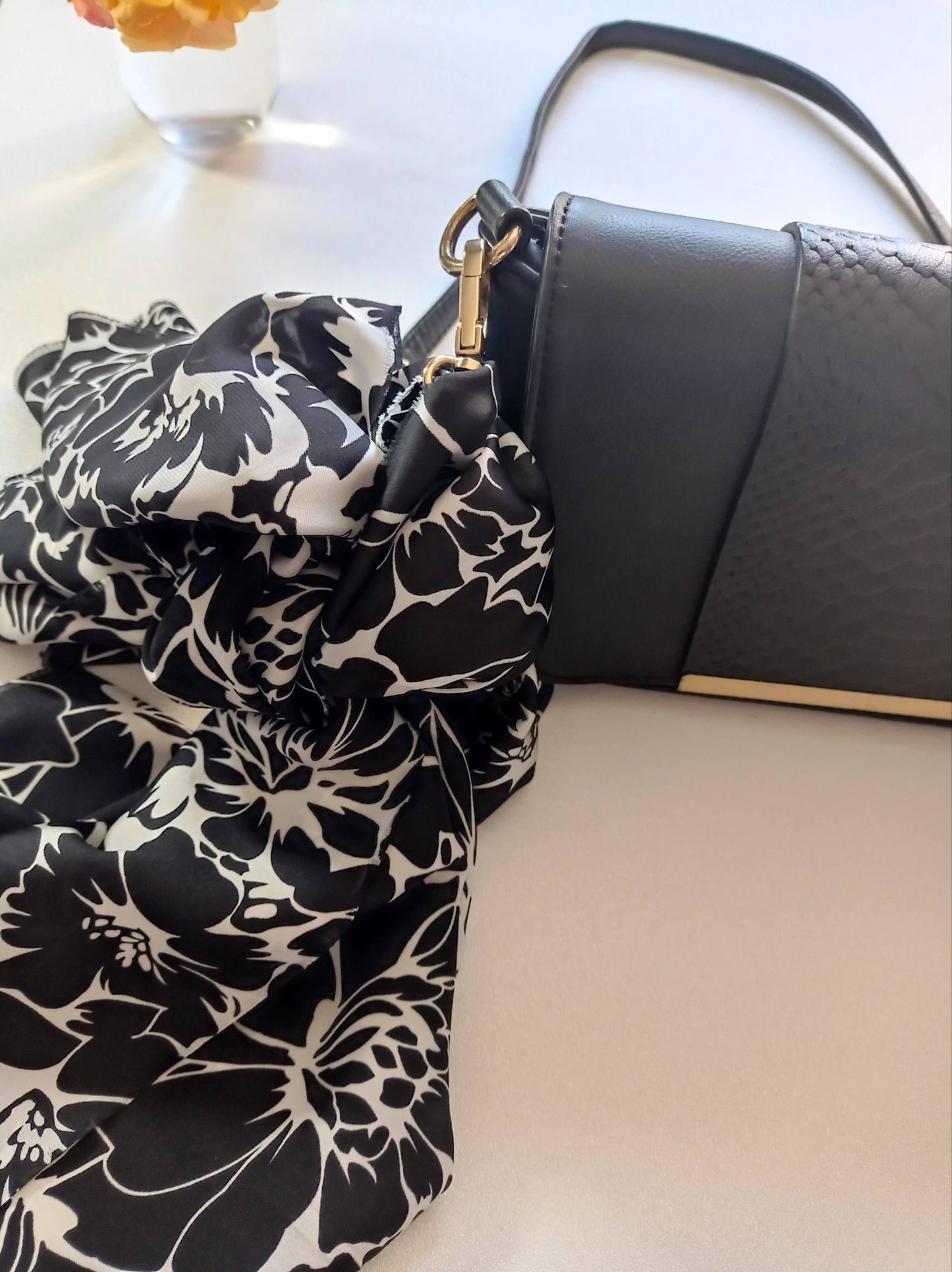 étoffe soyeuse noir et blanche accrochée à un sac à main