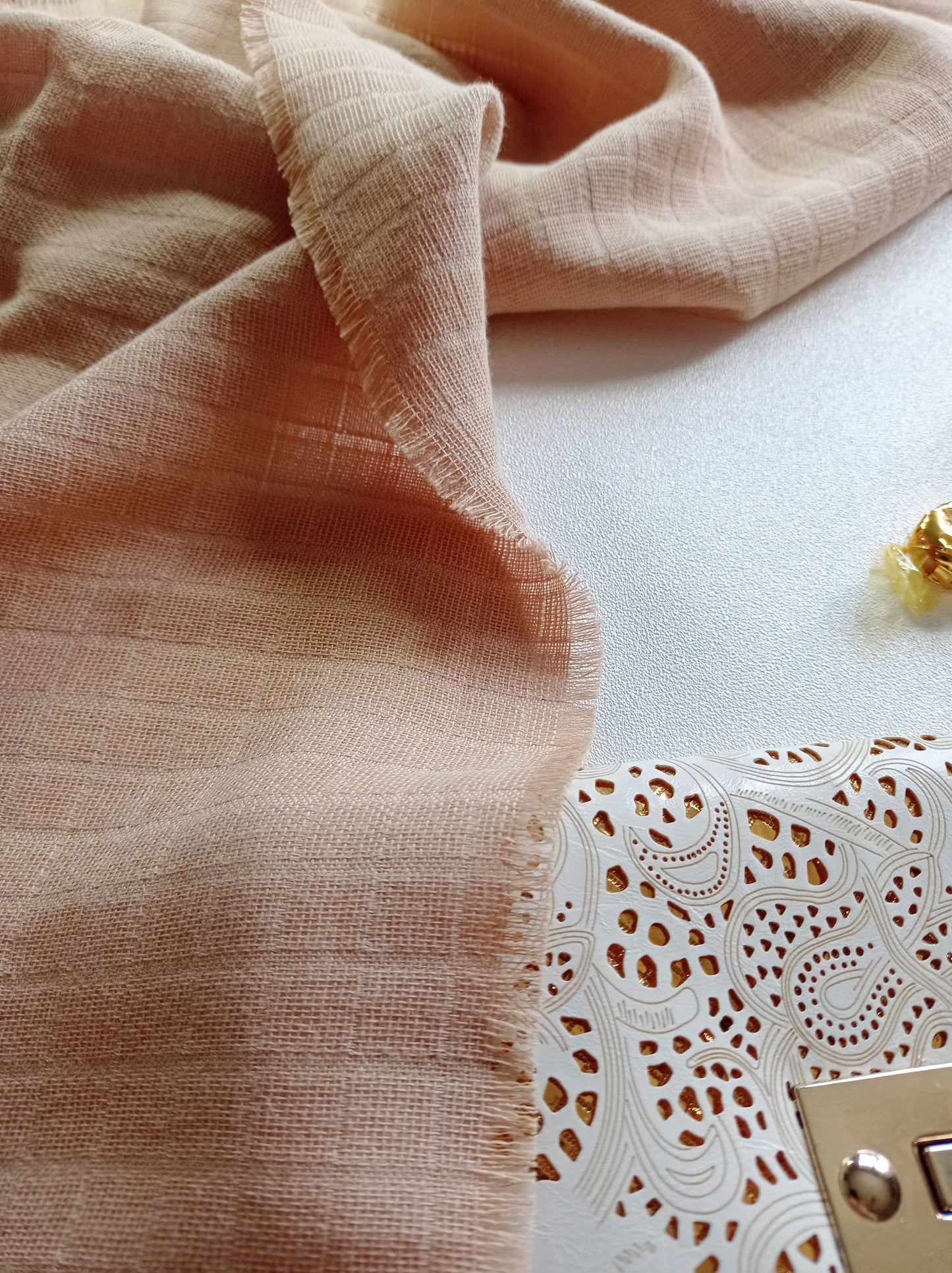 Gros plan tissu à franges beige assorti d'un sac pochette blanc or