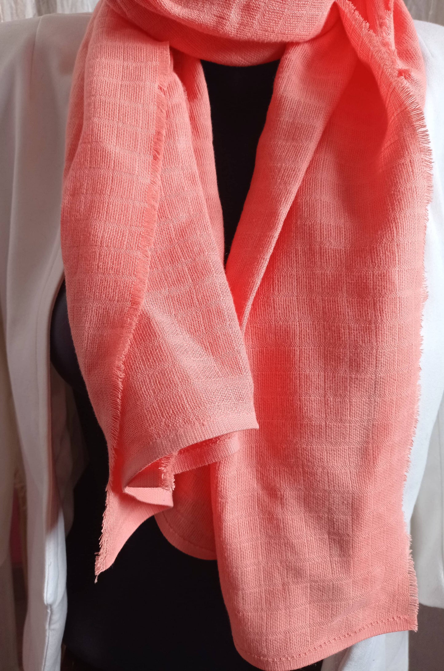 Écharpe corail sur buste avec veste blanche