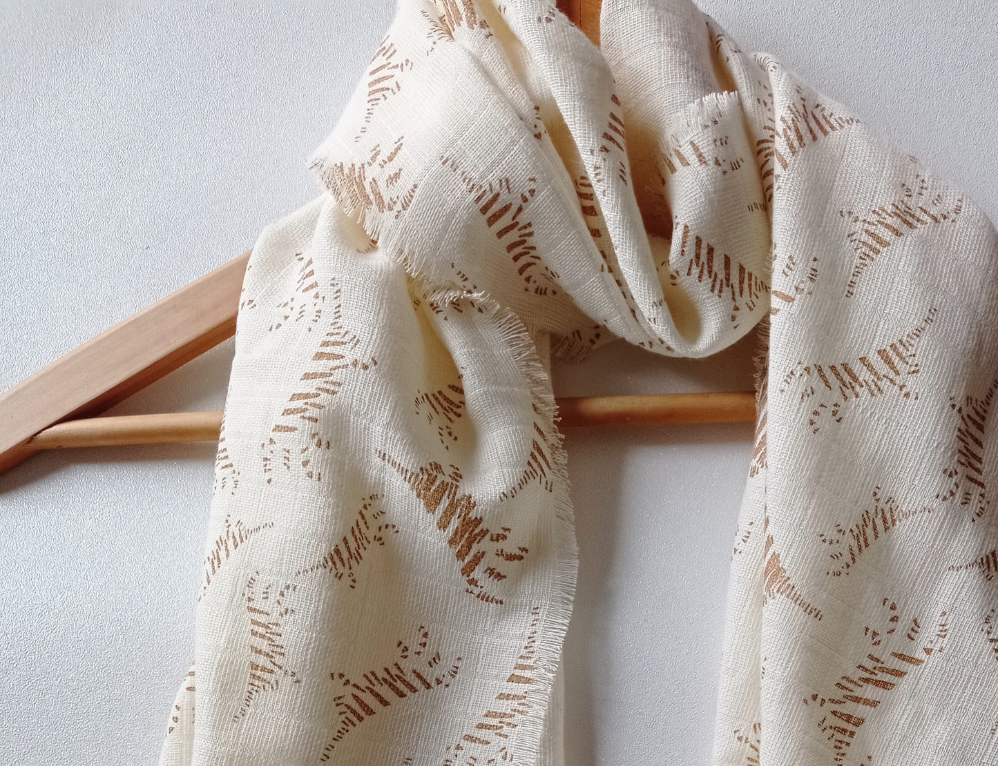 Gros plan Col beige crème motif tigré beige sur cintre en bois